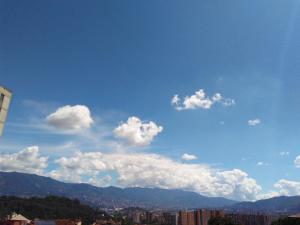 un cielo azul con nubes blancas y una ciudad en APARTAMENTO MEDELLIN, en Medellín