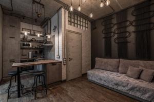 een keuken en een woonkamer met een bank en een tafel bij Eco Apartments in french quarter in Kiev