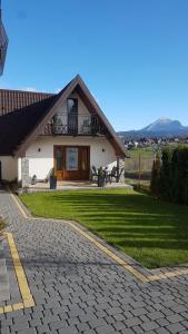 a house with a green lawn in front of it at Domek u Bizioma in Murzasichle