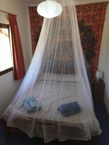 a bed with a net on top of it at Sonidos del Mar in Punta Del Diablo