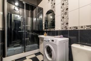 uma casa de banho com uma máquina de lavar roupa e um WC em Apartments for your happiness em Dnipro