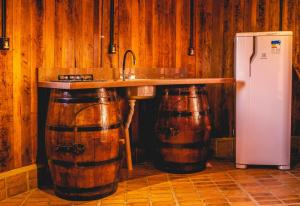 a kitchen with a sink and two wine barrels at Pousada Botte di Vino in Garibaldi