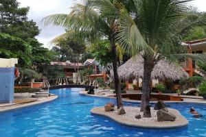 una piscina con una palmera en un complejo en CocoMarindo, en Coco