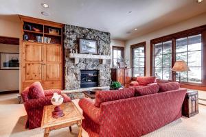 a living room with two couches and a stone fireplace at Bachelor Gulch Collection by East West Hospitality in Avon