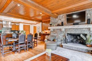 a living room with a stone fireplace with a television at Bachelor Gulch Collection by East West Hospitality in Avon