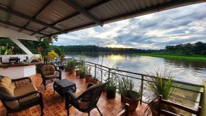 a balcony with chairs and a view of a river at Tortuguero Adventures GuestHouse in Tortuguero