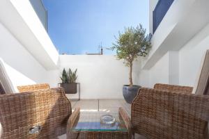 um pátio no sótão com cadeiras de vime e uma mesa em STUPENDO-Three Rooms-Suite with Terrace -Center -Air conditioning-Free Park em Lisboa
