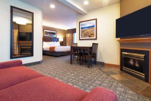 een hotelkamer met een bank en een open haard bij Best Western Rocky Mountain Lodge in Whitefish