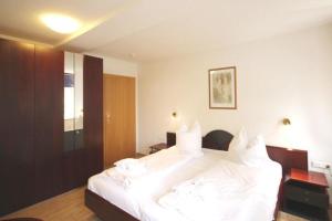 ein Schlafzimmer mit einem großen weißen Bett mit weißen Kissen in der Unterkunft Residenz Ostseewind - Wohnung 21 / 9659 in Kühlungsborn
