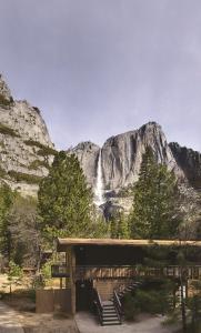 ein Gebäude mit einer Treppe vor einem Wasserfall in der Unterkunft Yosemite Valley Lodge in Yosemite Village