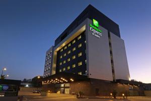 een groot gebouw met een verlicht bord erop bij Holiday Inn Express & Suites - Ensenada Centro, an IHG Hotel in Ensenada