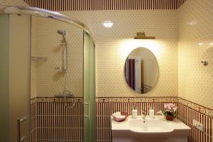 a bathroom with a sink and a shower and a mirror at Hotel Litera in Dnipro