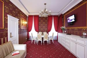 Hotel Litera في دنيبروبيتروفسك: غرفة طعام مع ستائر حمراء وطاولة وكراسي