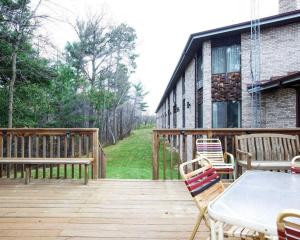 una terraza de madera con mesa y sillas. en Econo Lodge Inn & Suites, en Stevens Point