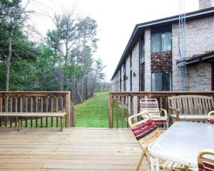 a wooden deck with a table and chairs on it at Econo Lodge Inn & Suites in Stevens Point