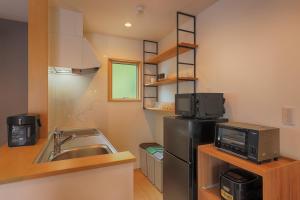 a small kitchen with a sink and a refrigerator at Villas Asama no Iori in Fujiyoshida