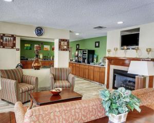 uma sala de estar com mobiliário e uma lareira em Quality Suites Baton Rouge East - Denham Springs em Baton Rouge