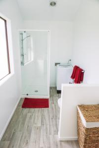 
a small bathroom with a shower, sink, and toilet at The Barn Cabins & Camp in Marahau
