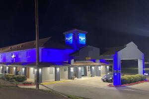 a building with blue lights on it at night at Rodeway Inn in Stephenville