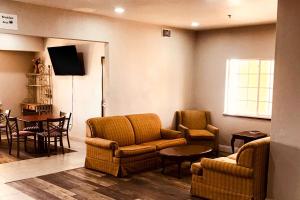 a waiting room with two chairs and a tv at Rodeway Inn in Stephenville