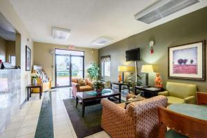 a living room with couches and chairs and a tv at Econo Lodge in Athens
