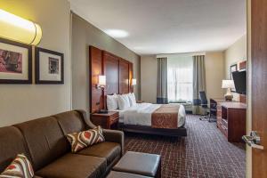 a hotel room with a bed and a couch at Comfort Suites NW Dallas Near Love Field in Dallas