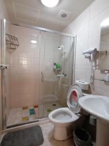a bathroom with a shower and a toilet and a sink at 紅築民宿 in Jincheng