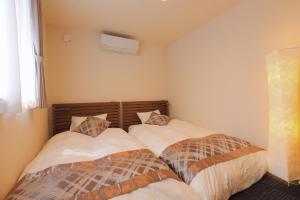 two beds in a small room withermottermott at Villas Asama no Iori in Fujiyoshida