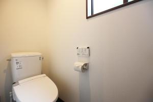 a bathroom with a white toilet and a window at Villas Asama no Iori in Fujiyoshida