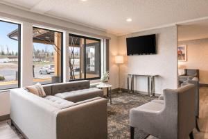 a living room with a couch and chairs and a tv at Quality Inn in Marquette