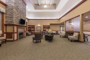 a lobby with a fireplace and chairs and a living room at Clarion Hotel & Suites Williston in Williston