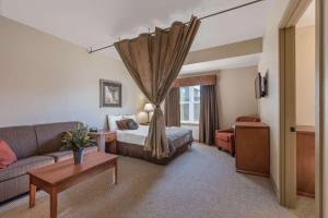 a hotel room with a bed and a couch at Clarion Hotel & Suites Williston in Williston