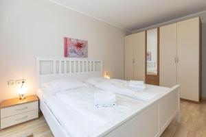 キュールングスボルンにあるHaus-Mecklenburg-FeWo-Senta-Wohnung-11-920の鏡付きの客室内の大きな白いベッド