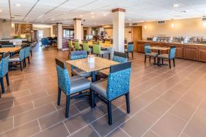 a dining room with tables and chairs and a cafeteria at Comfort Inn in Waukesha