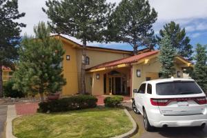 a white car parked in front of a house at Quality Inn Aurora Denver in Aurora