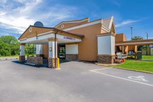 a building with a gas station on a street at Quality Inn in Gastonia