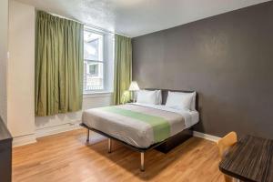 a bedroom with a bed and a window with green curtains at Quality Inn & Suites Kansas City Downtown in Kansas City