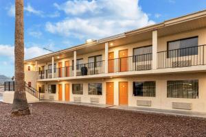 an apartment building with orange doors and a palm tree at Rodeway Inn Phoenix North I-17 in Phoenix