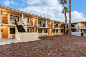 a building with a staircase in front of a palm tree at Rodeway Inn Phoenix North I-17 in Phoenix