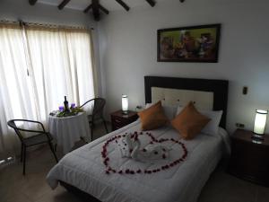 a bedroom with a bed with a heart made out at Posada Rural Villa Rouse in Guachantivá