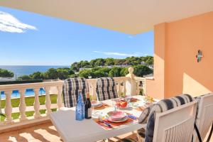 a table and chairs on a balcony with a view of the ocean at Poolbeach V in Moraira