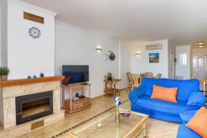 sala de estar con sofá azul y chimenea en Poolbeach V, en Moraira