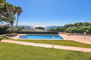 una piscina con vista sull'oceano sullo sfondo di Poolbeach VI a Moraira