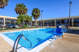 a swimming pool with a blue chair next to a building at Quality Inn New Orleans I-10 East in New Orleans