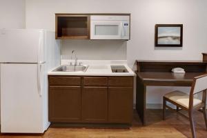 a small kitchen with a sink and a refrigerator at WoodSpring Suites Las Colinas - Northwest Dallas in Irving