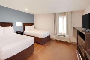 Postel nebo postele na pokoji v ubytování WoodSpring Suites Las Colinas - Northwest Dallas