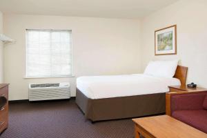 a hotel room with a bed and a window at WoodSpring Suites Fort Worth Forest Hill in Forest Hill