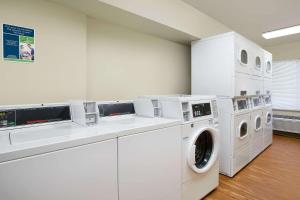 una lavanderia con lavatrici e asciugatrici bianche di WoodSpring Suites Fort Worth Forest Hill a Forest Hill