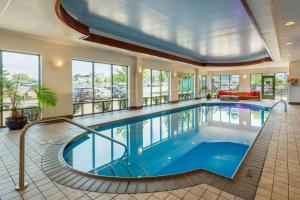 a swimming pool in a building with a large room with windows at Comfort Inn & Suites Logan International Airport in Revere