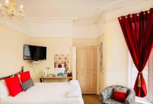 ein Wohnzimmer mit einem weißen Sofa und einem roten Vorhang in der Unterkunft Brick lane stay in London